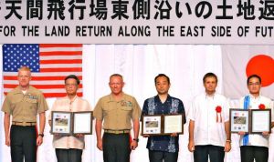 土地返還式で記念証を交わした(左から)ポール・ロック米海兵隊太平洋基地司令官、翁長雄志知事、ローレンス・ニコルソン在沖米四軍調整官、宮沢博行防衛政務官、ジュエル・エレンライク在沖米総領事、佐喜真淳宜野湾市長=1日、宜野湾市・ラグナガーデンホテル沖縄