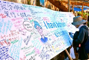 翁長知事への思いを書き込む集会の参加者=18日、名護市辺野古