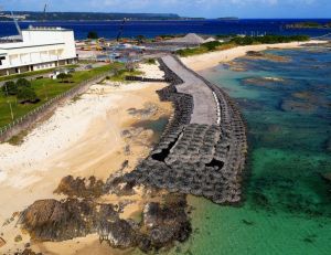 護岸工事着手から半年。N5護岸建設予定地近くに造られた作業用の仮設道路が、波打ち際から海に延びる=24日午後、名護市辺野古の米軍キャンプ・シュワブ(小型無人機から)