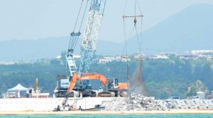 「K4」護岸接続のために海中に投入される砕石=30日、名護市辺野古・キャンプ・シュワブ沿岸