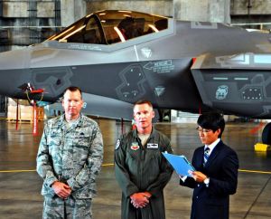 F35Aの前で報道陣の質問に答えるジェイソン・ルーシュオフ大佐(中央)とマイケル・マイルズ大佐(左)=7日、米軍嘉手納基地