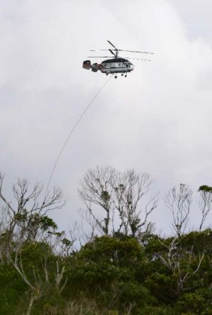 積み荷を下ろしてH地区上空付近を飛ぶ民間ヘリ=14日午前10時43分ごろ、東村高江(提供)