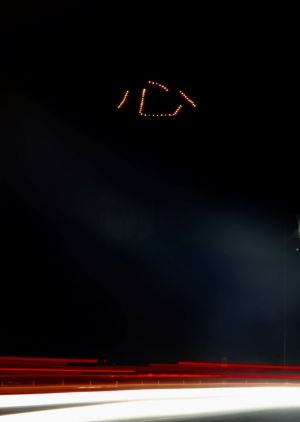 「心」の光文字は国道58号からもはっきり見える=8日午後8時前、名護市城(8秒間露光)
