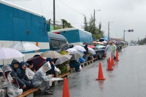 雨の中、座り込んで新基地建設に抗議する市民ら=22日、名護市辺野古、米軍キャンプ・シュワブゲート前