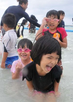 「寒ーい」と声を上げながらも、大はしゃぎする子どもたち=21日、石垣市真栄里・マエサトビーチ