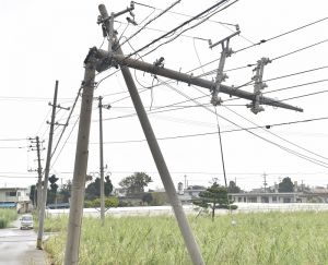 くの字に折れた電柱。電線の被害が島のあちらこちらで見られた=4日午後、久米島町嘉