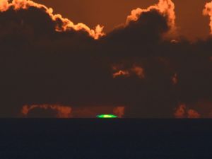 夕日が水平線に沈む瞬間に確認されたグリーンフラッシュ=6月27日午後7時35分、石垣市新川の丘から(北島清隆さん撮影)