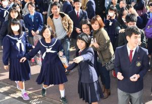 掲示板に自分の番号を見つけ喜ぶ受験生ら=15日午前9時、沖縄市・球陽高校