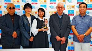 大賞に選ばれた奥浜祥子さん(中央)と審査委員ら=6日、那覇市久茂地・琉球放送