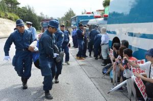 座り込み抗議をしている市民を強制排除する機動隊=15日、名護市辺野古の米軍キャンプ・シュワブゲート前