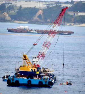 次々と海中に投下される汚濁防止膜固定用のコンクリートブロック=31日午後3時14分、名護市・大浦湾(城間陽介撮影)