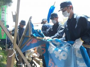 市民が歩道脇に作った簡易の日よけテントや、横断幕を撤去する機動隊員=4日午前11時38分、米軍キャンプ・シュワブゲート前