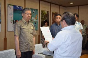 川田司外務省沖縄担当大使へ抗議文を手渡す安慶田光男副知事=23日午前9時55分ごろ、県庁