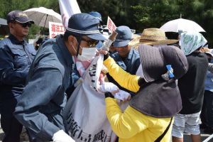 横断幕を撤去する機動隊と、抵抗する市民=2日午前、名護市辺野古の米軍キャンプ・シュワブ前