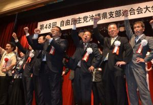 党勢拡大に向けガンバロー三唱で気勢を上げる自民党県連の照屋守之会長(右から3人目)ら=8日、那覇市・ロワジールホテル
