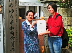 島袋淑子館長(左)から認定証を手渡される石本茉穂さん=28日、糸満市伊原・ひめゆり平和祈念資料館
