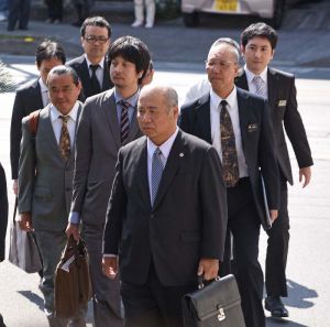 那覇地裁に入る県側代理人弁護士と職員=13日午後2時45分ごろ