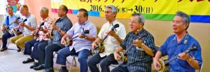 会見で、「かぎやで風節」を披露する安慶田副知事(右から4人目)や古典音楽実演家ら=7日、沖縄県庁