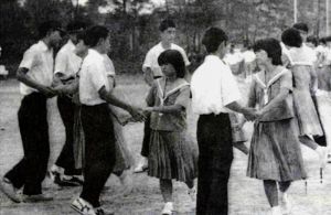 1980年代、羽地中学校の運動会でフォークダンスを踊る生徒。「青い山脈」も踊っていたとみられる(「羽地中創立50周年記念誌」より)
