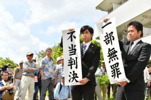 判決を受け、垂れ幕を掲げる弁護士=14日午後1時36分、那覇市楚辺・城岳公園