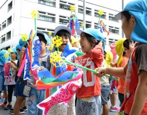 プレゼントされた小さいこいのぼりを手に喜ぶ園児たち=24日、県庁