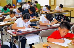 真剣な表情でそろばんに向かう子どもたち=浦添市伊祖・全国珠算教育連盟県支部