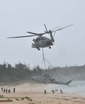 CH53につり下げられ撤去される不時着したUH1Yヘリ=8日午前10時16分、うるま市・伊計島