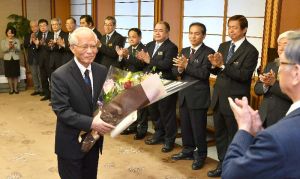 花束を受け取り笑顔を見せる浦崎唯昭副知事(左)=30日午前、県庁