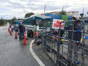 新基地建設に抗議し座り込む市民は、新しく設置された柵(右手前)が「おりのようだ」と訴えた=13日、名護市辺野古