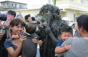 厄払いの泥を住民らに塗りたくるパーントゥ=25日、宮古島市平良島尻