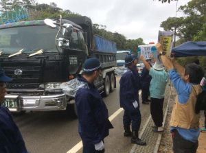 ボードを掲げて工事車両の進入に反対する市民ら=14日午前9時半ごろ、東村高江