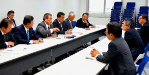 中嶋浩一郎沖縄防衛局長(右から2人目)らに抗議する宜野湾市議会の大城政利議長(左から4人目)ら議員=23日、嘉手納町・沖縄防衛局