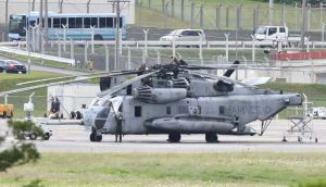 CH53E大型輸送ヘリの窓のない部分をシートで覆う作業員=13日午前11時52分、宜野湾市・米軍普天間飛行場(田嶋正雄撮影)