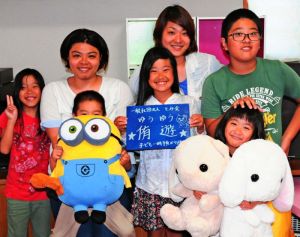 「ひとり親の子どもも親も支援したい」と話す金城里奈さん(後列左から2人目)と麻希さん(同3人目)姉妹。麻希さんの子どもたちも事業を応援している=7日、南城市大里