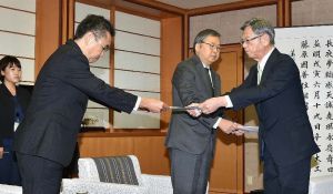 オスプレイの飛行停止を求め(左から)中嶋浩一郎沖縄防衛局長、川田司外務省沖縄担当大使に抗議文を手渡す翁長雄志知事(右)=14日午前、県庁