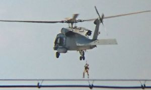 米海軍のHH60Hヘリから降下訓練をする兵士=18日、米軍嘉手納基地上空