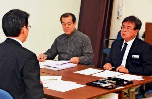 防衛局の遠藤次長(左)に抗議する名護市の山里副市長(右)=5日、名護市役所