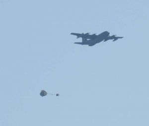 パラシュート降下訓練で物資を投下するMC130特殊支援機=22日午後4時54分、うるま市津堅場訓練場水域(大城志織撮影)