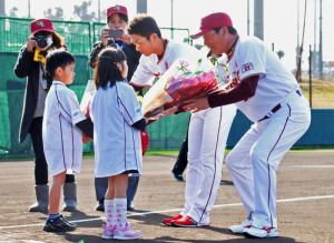 歓迎の花束を(右から)梨田監督と岡島選手会長に渡す金城ちゃん、松堂君=金武町ベースボールスタジアム