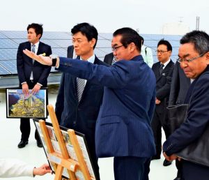 宜野湾市役所屋上から米軍普天間飛行場などを視察する西村康稔官房副長官(手前左)と説明する佐喜真淳宜野湾市長(同2人目)ら=12日