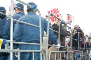 機動隊に排除され、ゲート横の柵に閉じ込められた座り込み市民ら=20日午前9時、名護市辺野古のキャンプ・シュワブ前