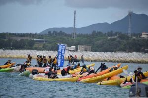 砕石投下が進む新基地建設現場で抗議の声を上げ、カヌーでフロートを越える市民ら=25日午前9時38分、名護市辺野古