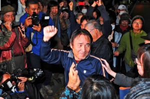 支援者とこぶしを挙げ、保釈を喜ぶ山城博治議長(中央)=18日午後8時12分、那覇市樋川・那覇拘置支所前(伊禮健撮影)