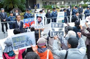 バリケードが張られた那覇地裁入り口で、山城博治議長らの早期釈放を求める人々=17日午前、那覇市樋川