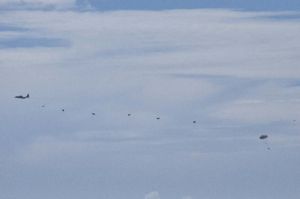 米空軍MC130特殊作戦機からパラシュートで降下する米兵士ら=12日正午、うるま市津堅島沖