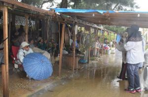 激しい雨の中、新基地建設に抗議する集会を続ける市民ら=13日、名護市辺野古