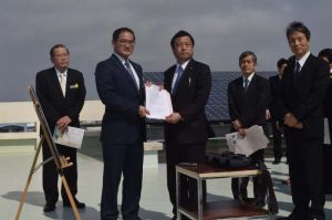 宜野湾市の佐喜真淳市長(左から2人目)から要請書を受け取る福井照沖縄担当相(同3人目)=4日午前、宜野湾市役所屋上