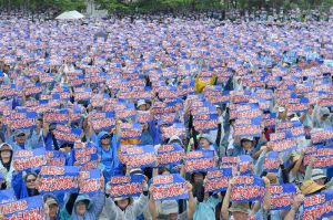 メッセージボードを掲げ「辺野古新基地建設断念」を訴える県民大会参加者=11日、那覇市・奥武山陸上競技場(下地広也撮影)
