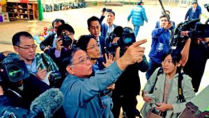 円筒があった場所を指さす緑ヶ丘保育園の神谷武宏園長(中央)=7日午後0時45分、宜野湾市野嵩