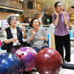 笑顔でボウリングを楽しむ(左から)宮里美子さん、長田光子さん、山里史さん=16日、那覇市・サラダボウル(崎浜秀也撮影)
